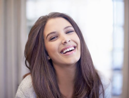 mujer joven sonriendo periodoncia e implantes monterrey