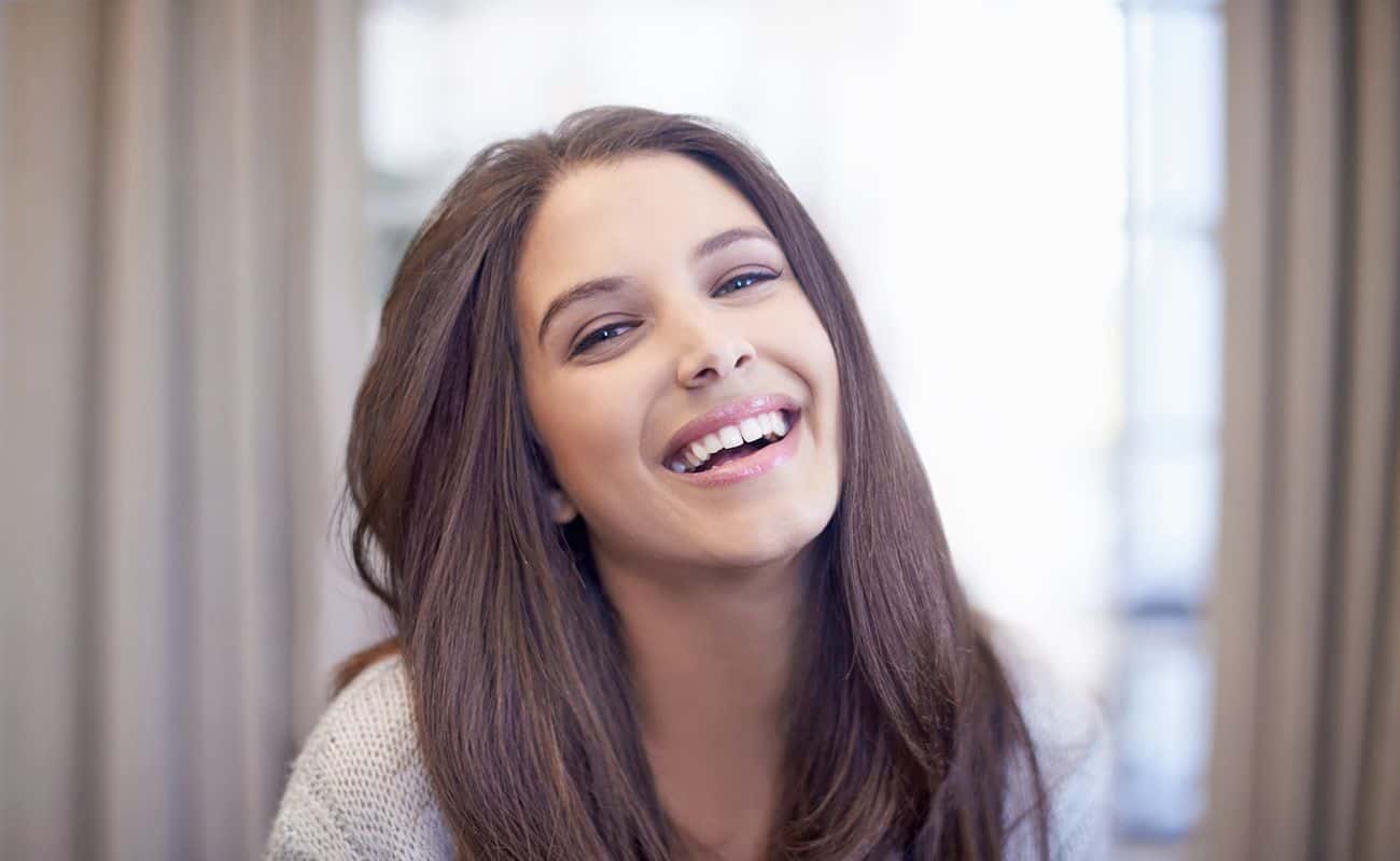 mujer joven sonriendo periodoncia e implantes monterrey